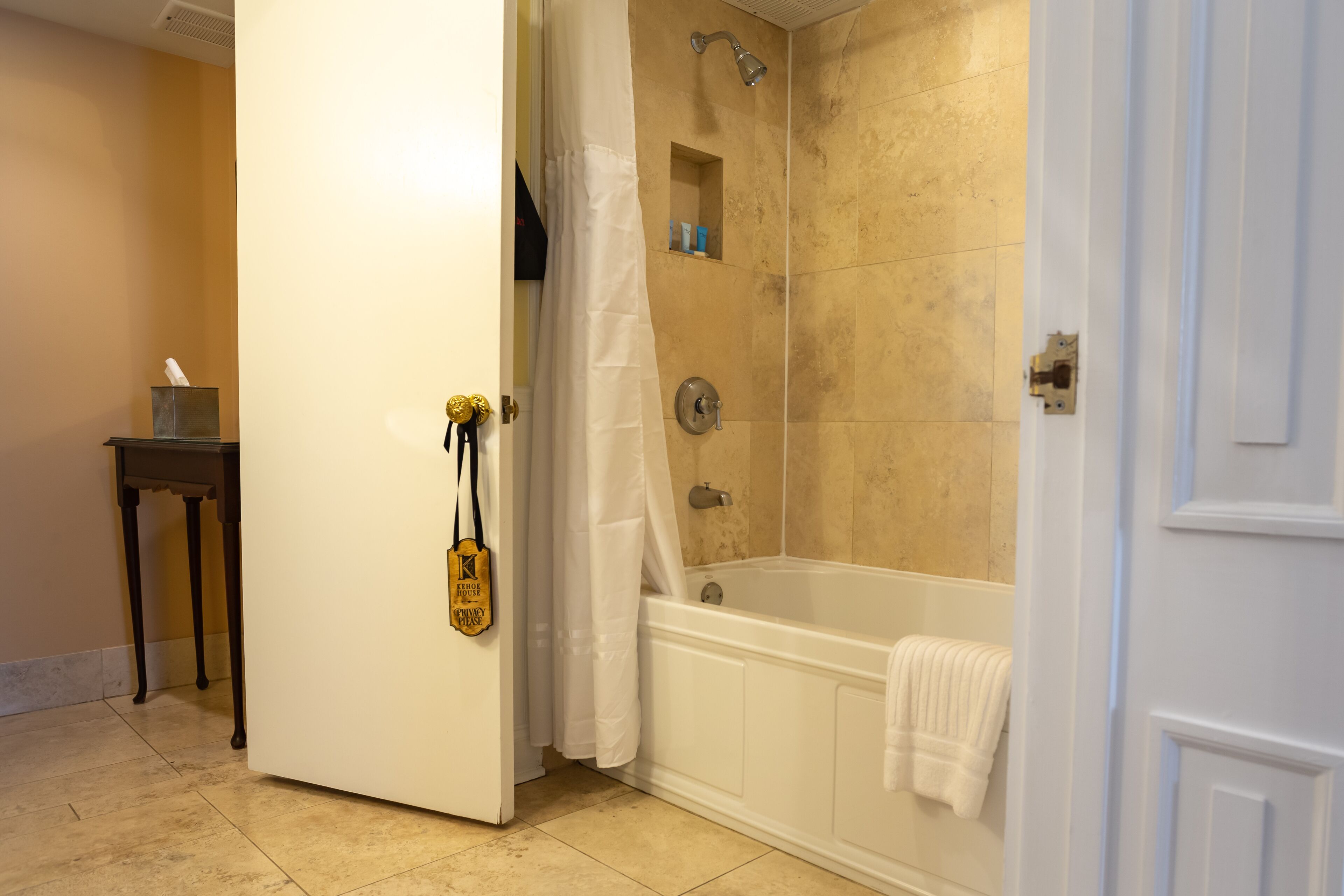 A bathroom with a bathtub, shower, and a towel rack.