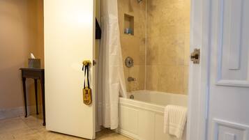 A bathroom with a bathtub, shower, and a towel rack.
