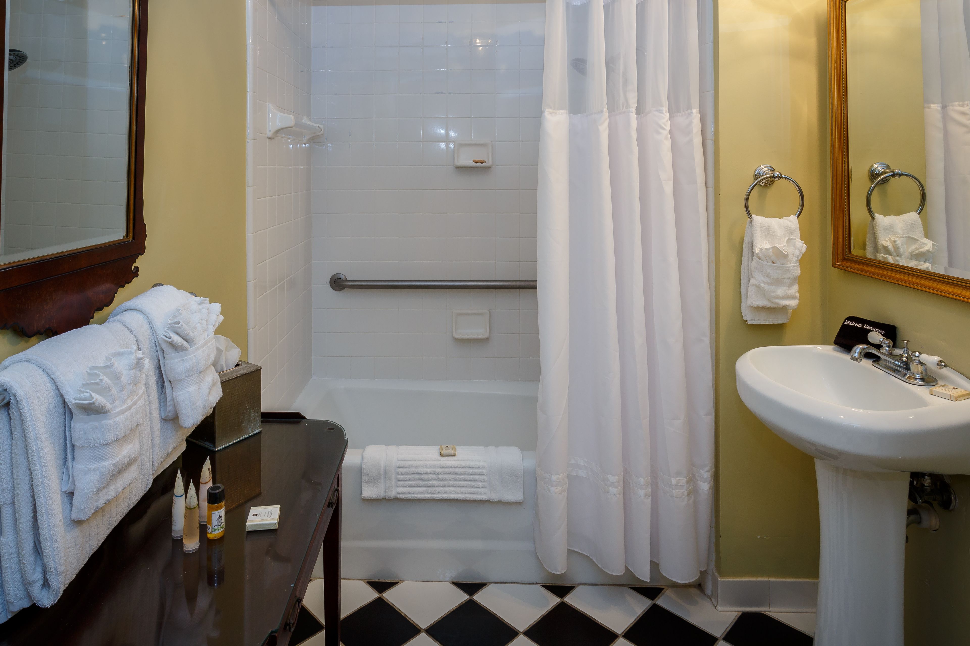 A bathroom with a bathtub, a sink, and a mirror.
