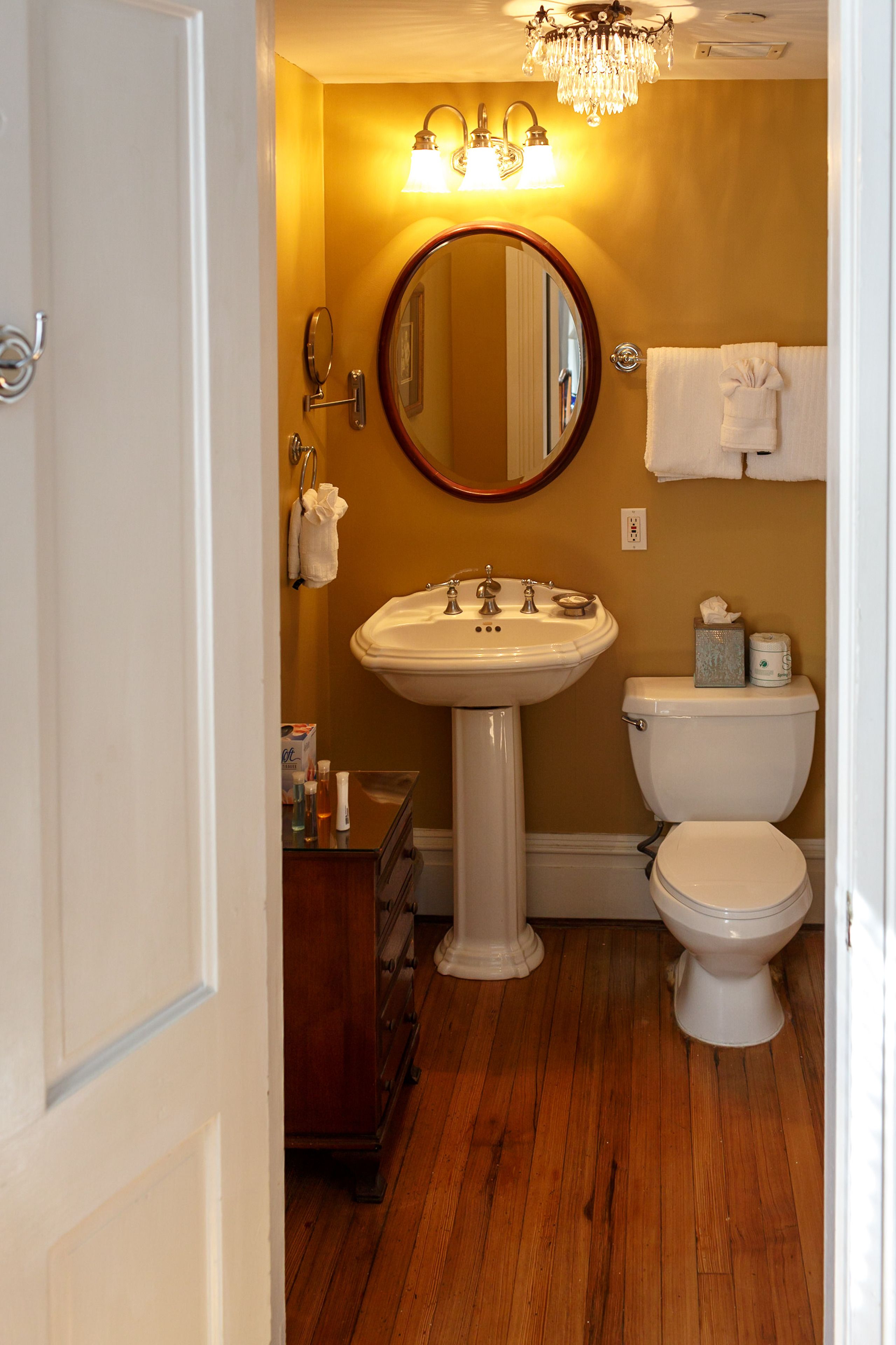 A bathroom with a sink, toilet, and mirror.