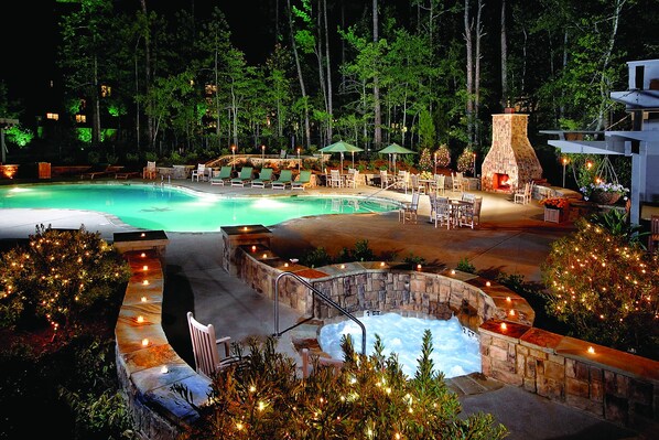 Una piscina al aire libre de temporada, sombrillas