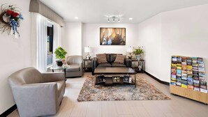 A modern living room with a sofa, armchair, coffee table, and a wall-mounted art piece. - Quality Inn Luray (Luray)