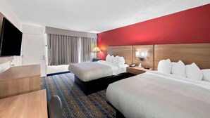 A hotel room with two beds, a desk, a TV, and a red accent wall. - Quality Inn Luray (Luray)