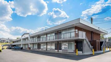 A modern hotel with a flat roof, large windows, and a covered entrance.