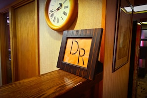 A wooden reception desk with a framed sign reading "DR" and a wall-mounted clock.
