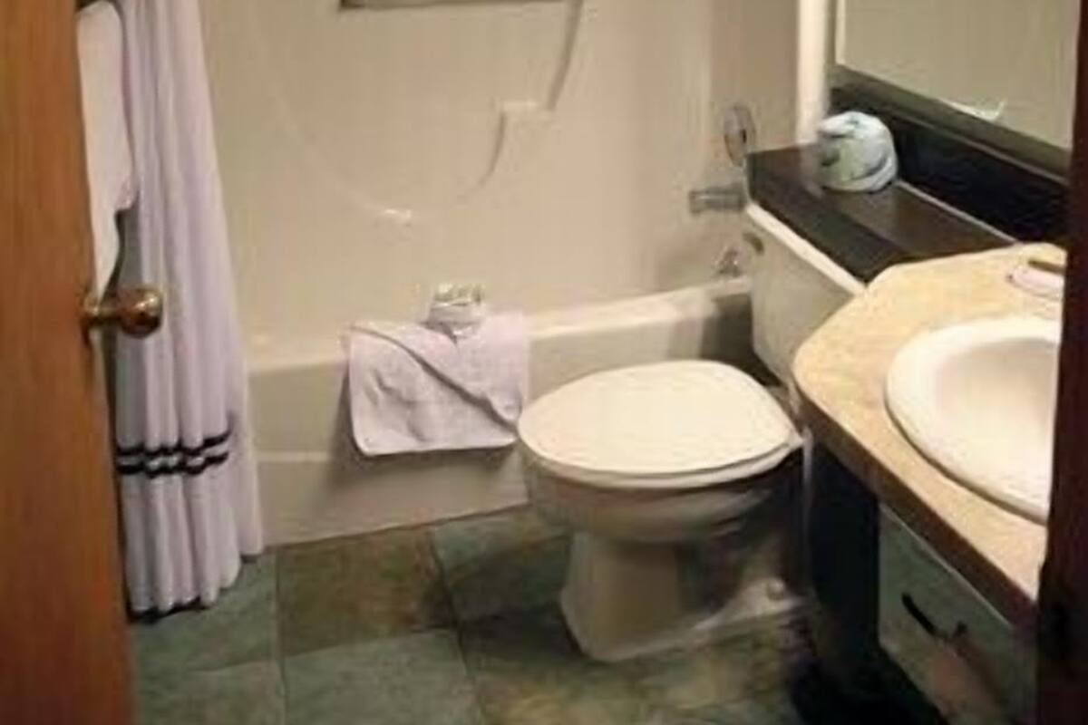 A bathroom with a bathtub, toilet, and sink.