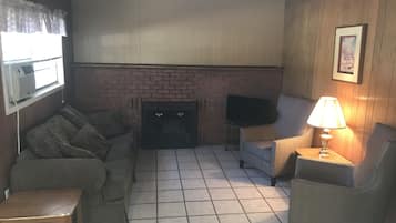 Cabaña estándar, 2 camas Queen size | Sala de estar | Televisión de pantalla plana, chimenea y tenis de mesa