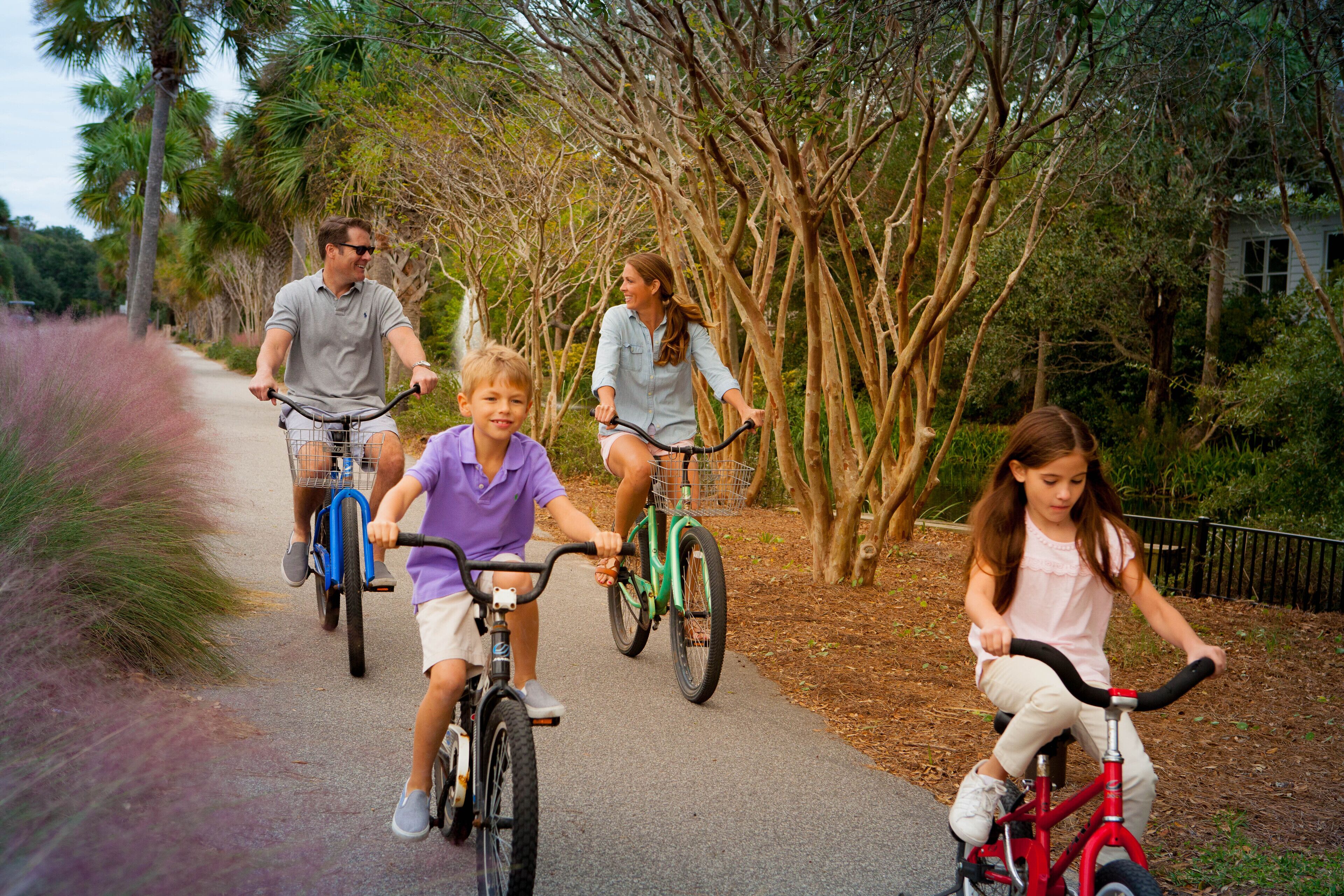 A pathway with four people riding bicycles.