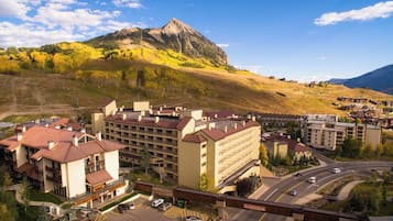 Un complesso alberghiero con diversi edifici, un'area di parcheggio e una montagna sullo sfondo.