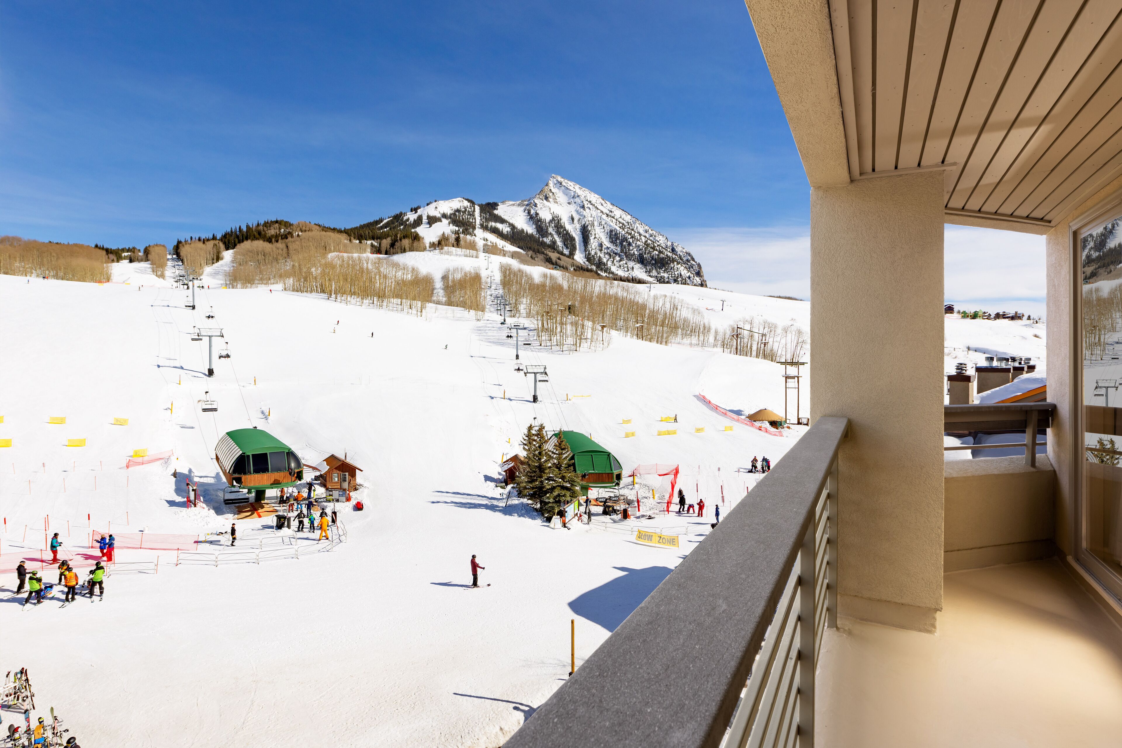 A ski resort with a chairlift, ski slopes, and a mountain backdrop.
