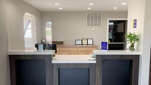 A reception area with a counter, framed certificates, and a plant. - Days Inn by Wyndham Wagoner (Wagoner)