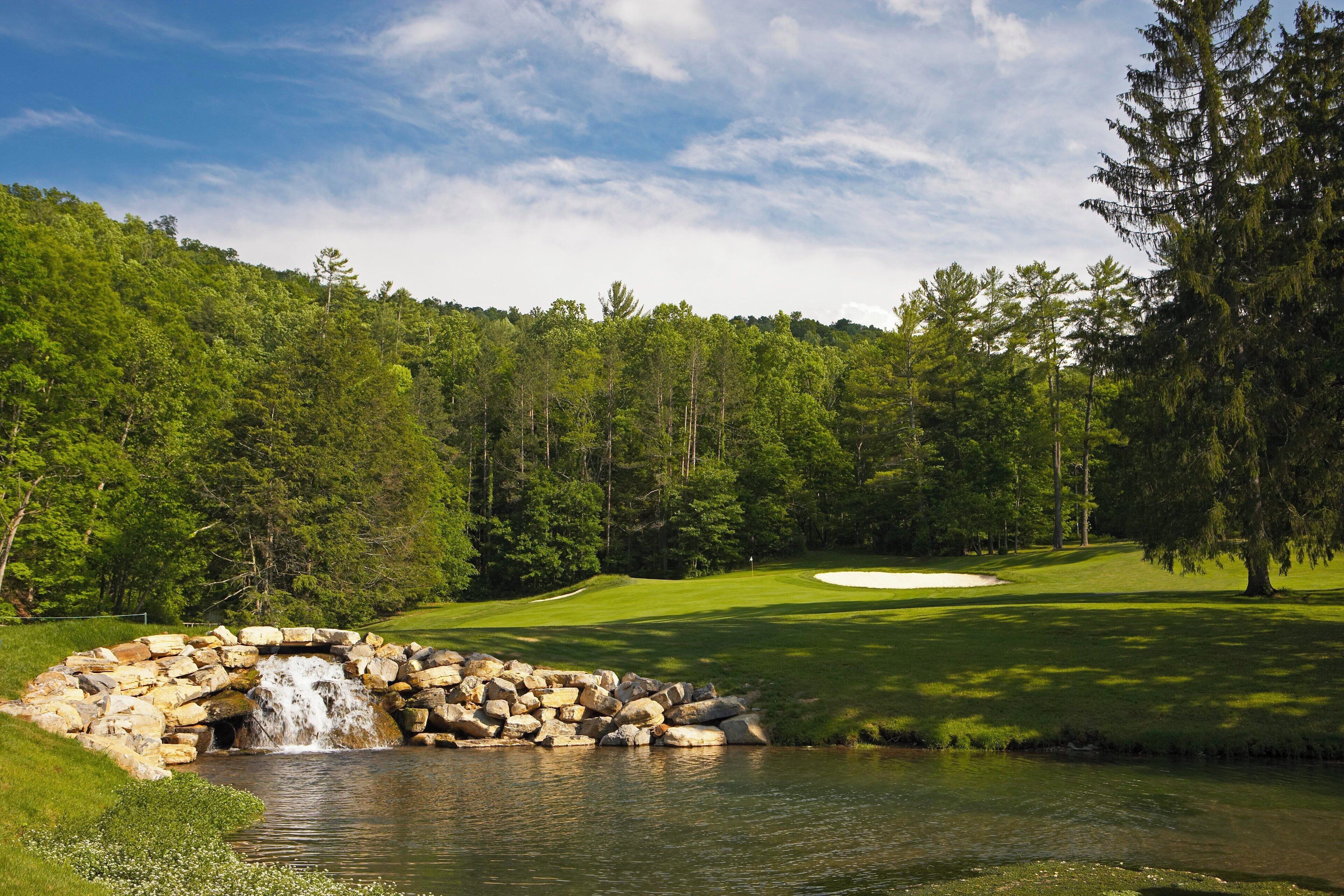 A golf course with a water feature and a pond.
