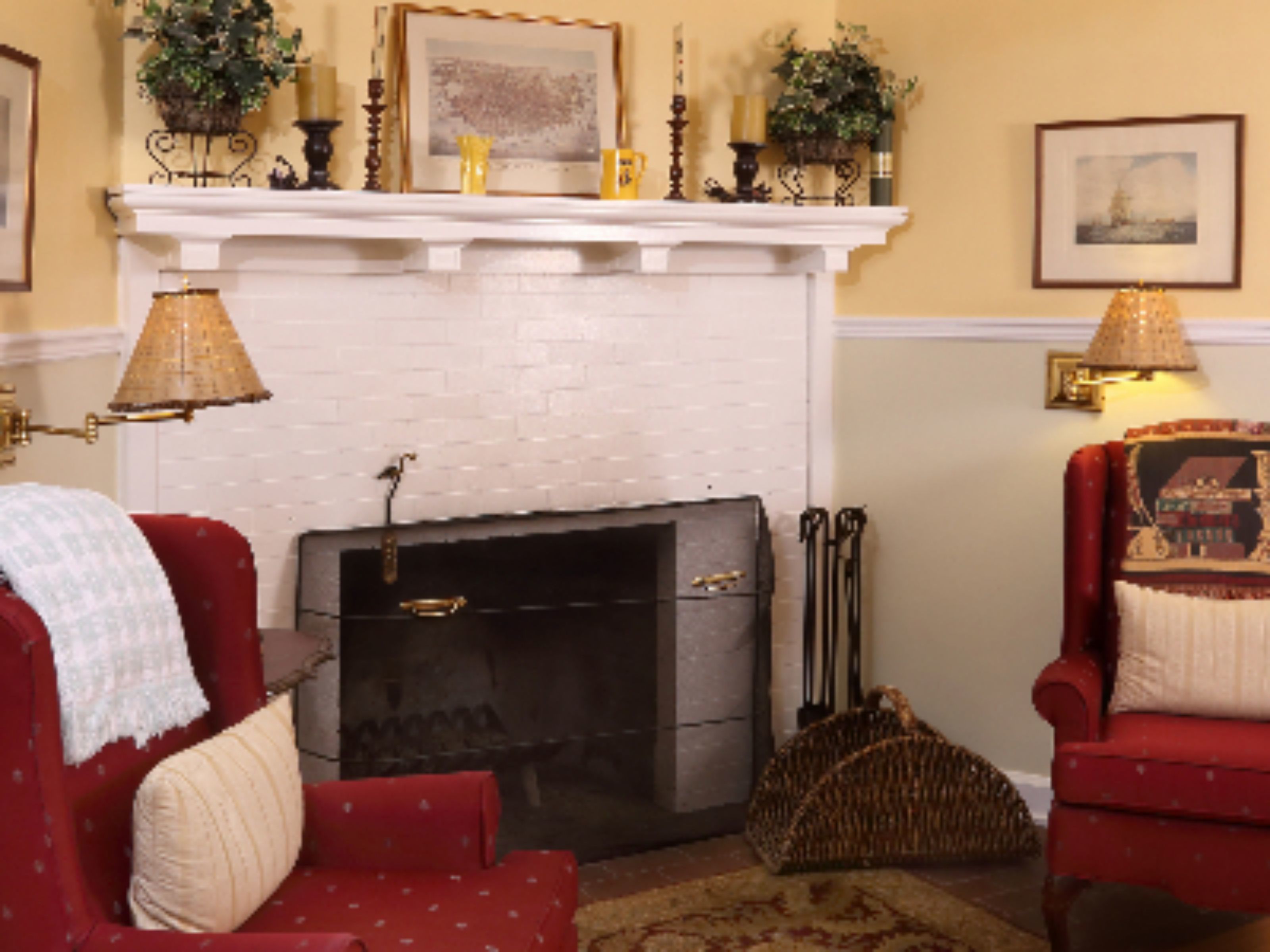 Una sala de estar acogedora con chimenea, sillones rojos y una repisa decorativa.
