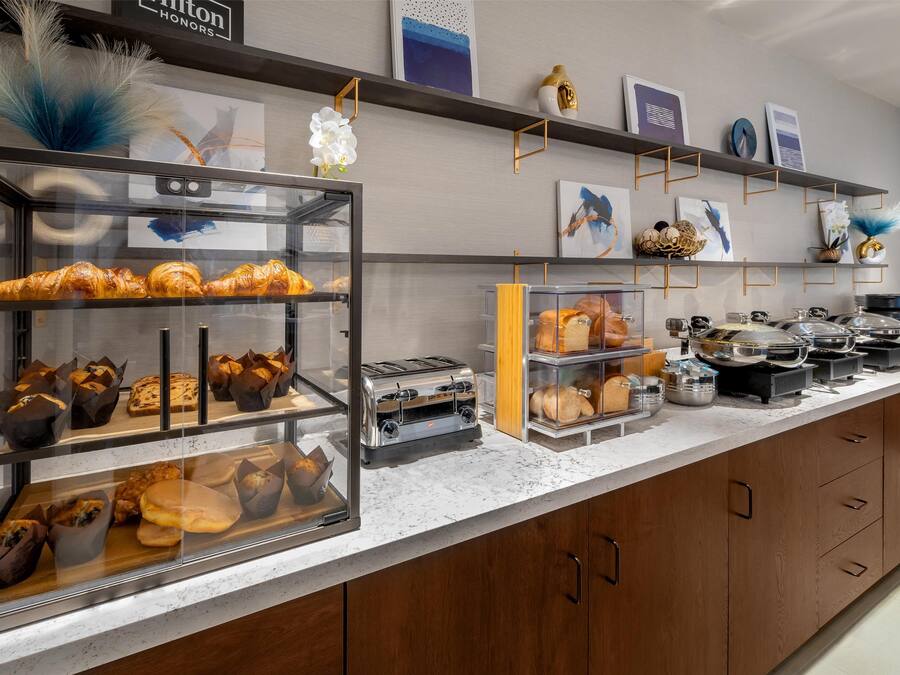Een bakkerij toonbank met diverse gebakjes en een broodrooster.