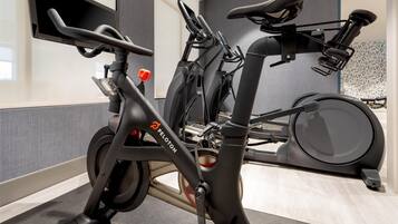A stationary bike with a digital display and a red emergency stop button.