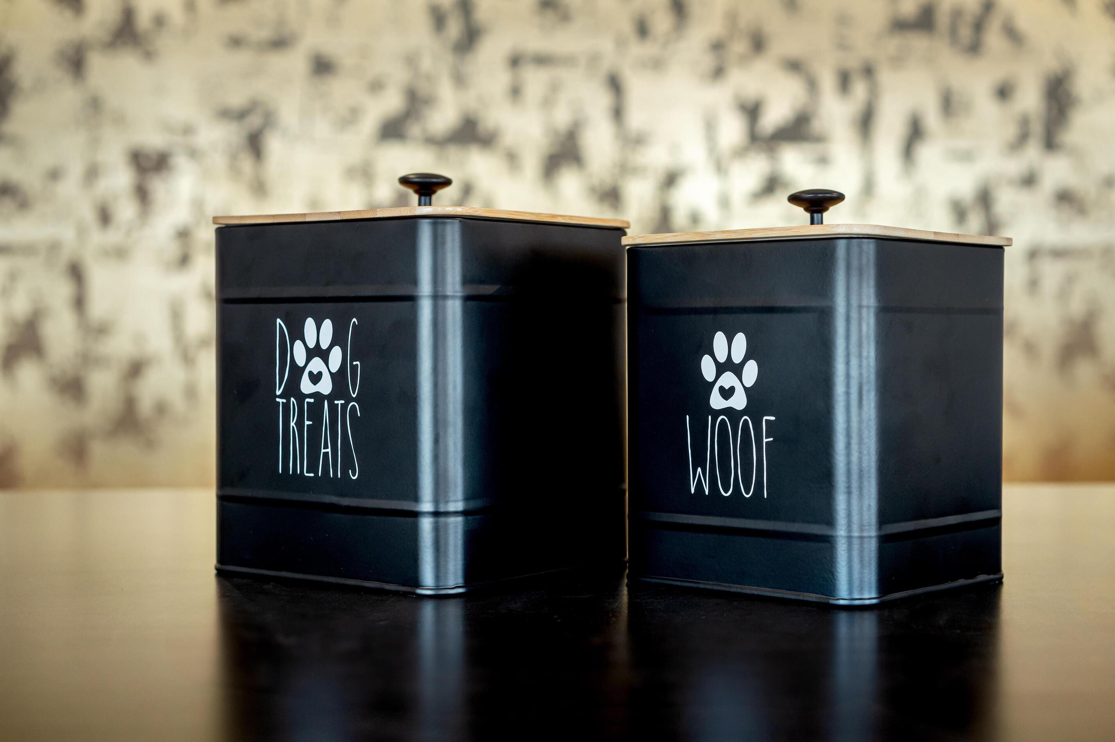 Two black metal containers with lids, each labeled with a paw print and the words "DOG TREATS" and "DOG WOOD" respectively.