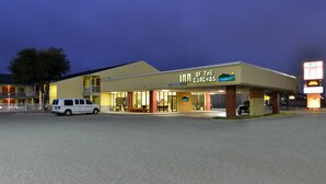 A motel with a sign reading "Inn of the Corchos" and a clear view of the entrance. - Inn of the Conchos (San Angelo)