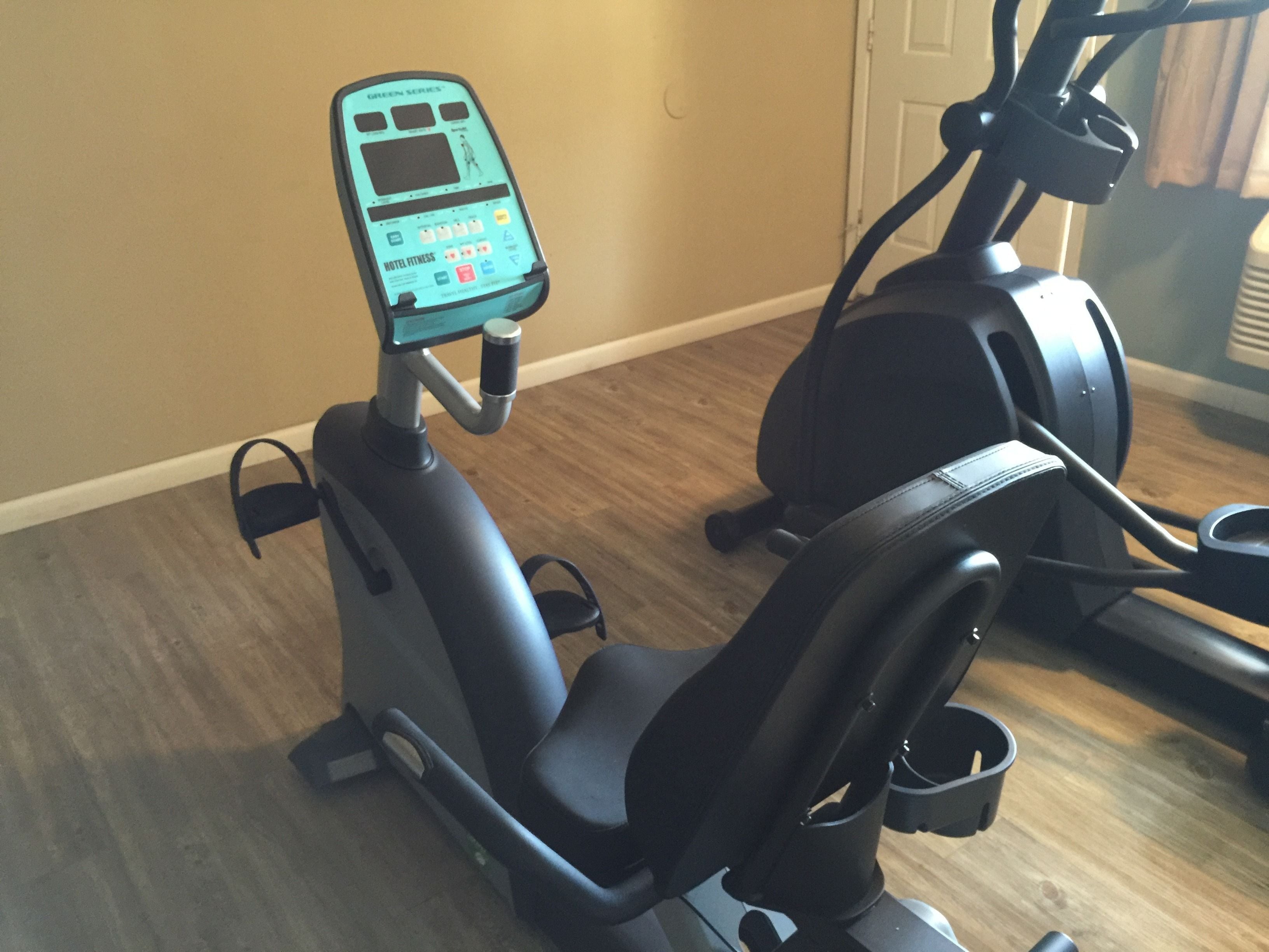 An exercise machine with a digital display, a control panel, and a seat.