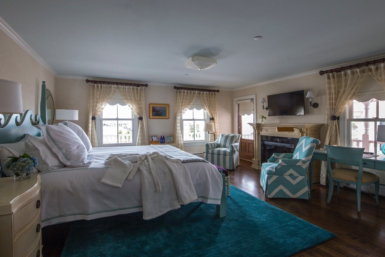 Une chambre d’hôtel équipée d’un lit, d’un bureau, d’une chaise, d’une télévision et d’une fenêtre avec des rideaux.