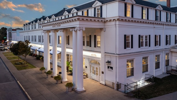 Un edificio grande y blanco con columnas y un letrero que dice "BOONE TAVERN HOTEL".