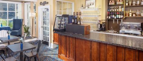 A bar area with a counter, seating, and a display of bottles.