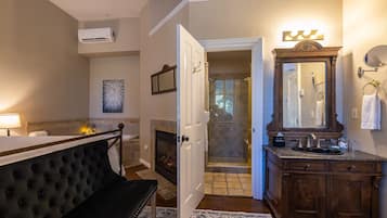 A bedroom with a bed, bedside table, and a fireplace.