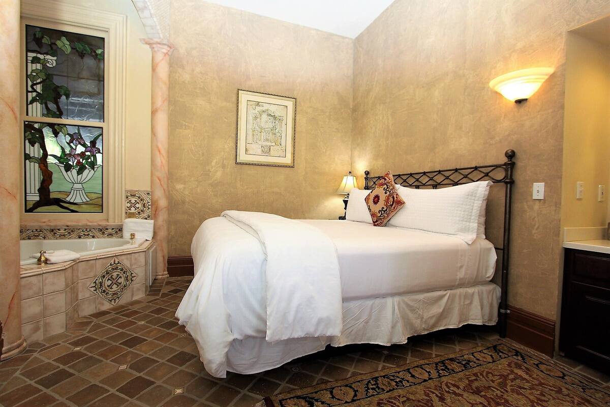 A neatly arranged bedroom with a bed, bedside lamp, and a decorative wall piece.