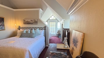 Ein Schlafzimmer mit einem großen Bett, einem Schreibtisch mit einem Buch und einem Sessel.