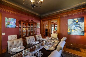 Comedor formal con una larga mesa dispuesta para seis comensales, rodeada de sillas tapizadas.