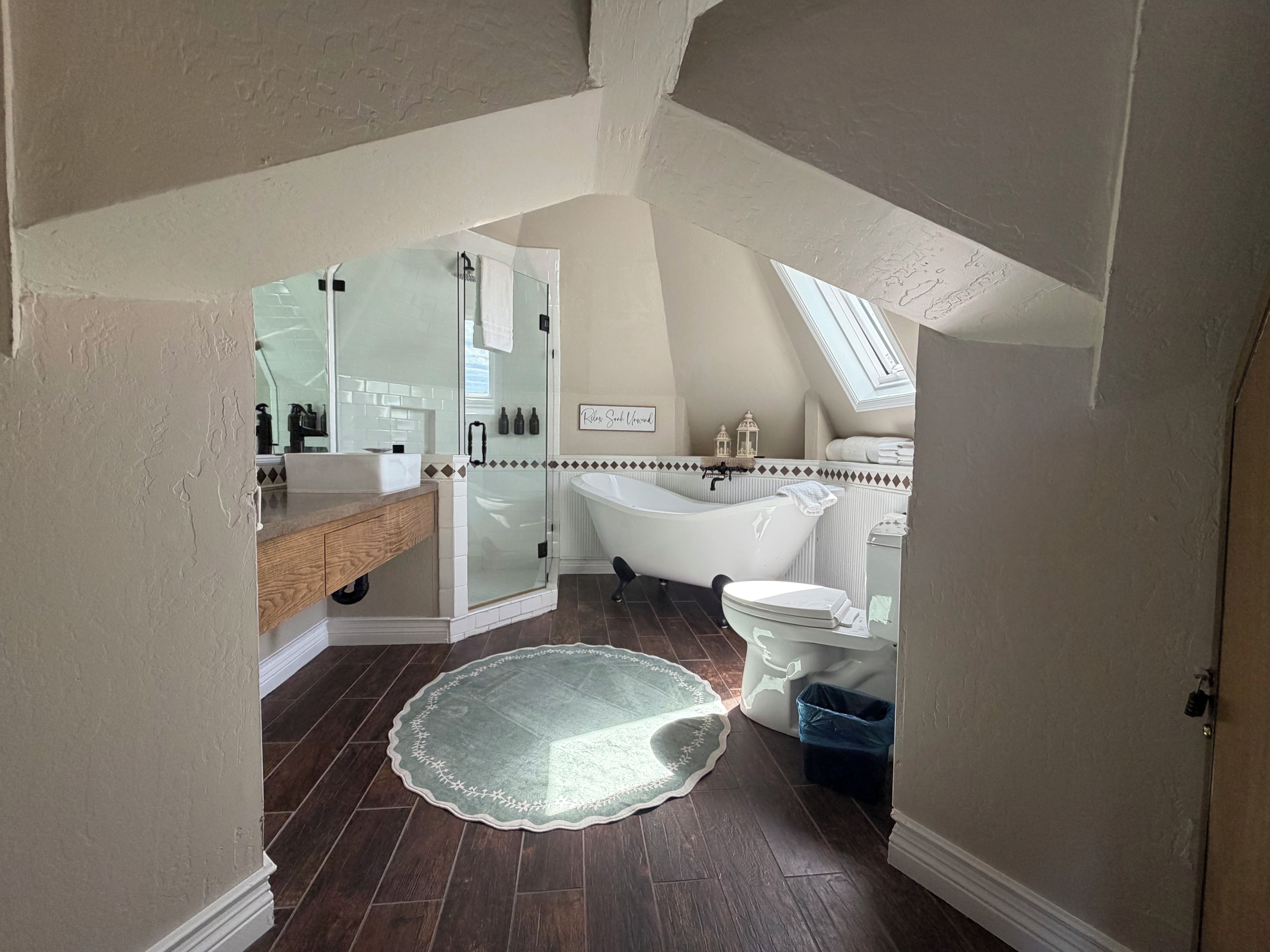 A bathroom with a bathtub, a glass-enclosed shower, and a vanity with a mirror.