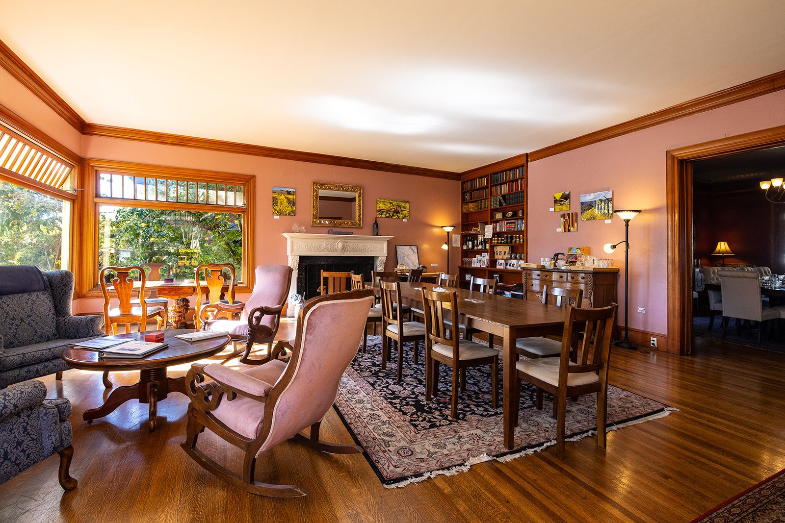 A spacious living room with a fireplace, a dining area, and a library.