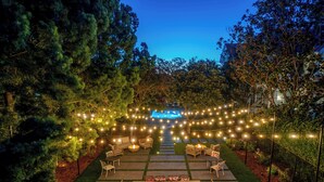 A well-lit outdoor patio area with string lights, a pool, and a seating arrangement. - White House Napa (Napa)