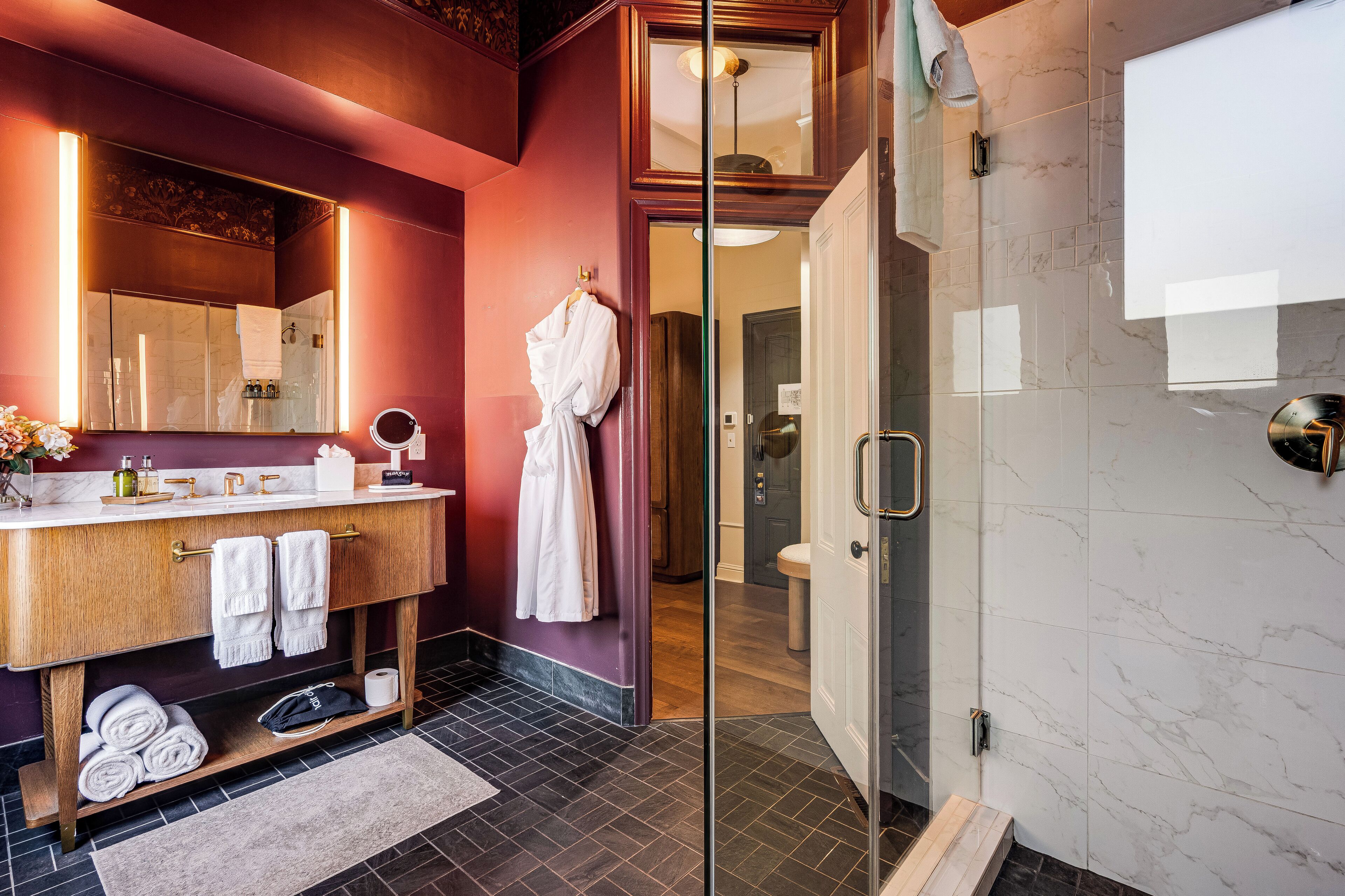 A modern bathroom with a vanity, mirror, and a walk-in shower.