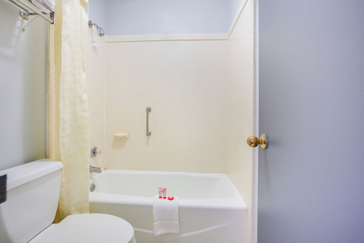 Un baño con inodoro, bañera y cortina de ducha.