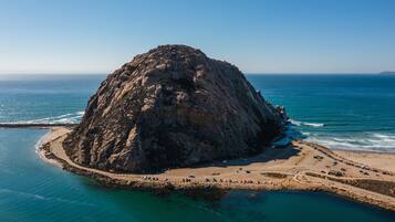 A rocky island with a beach and a road leading to it.