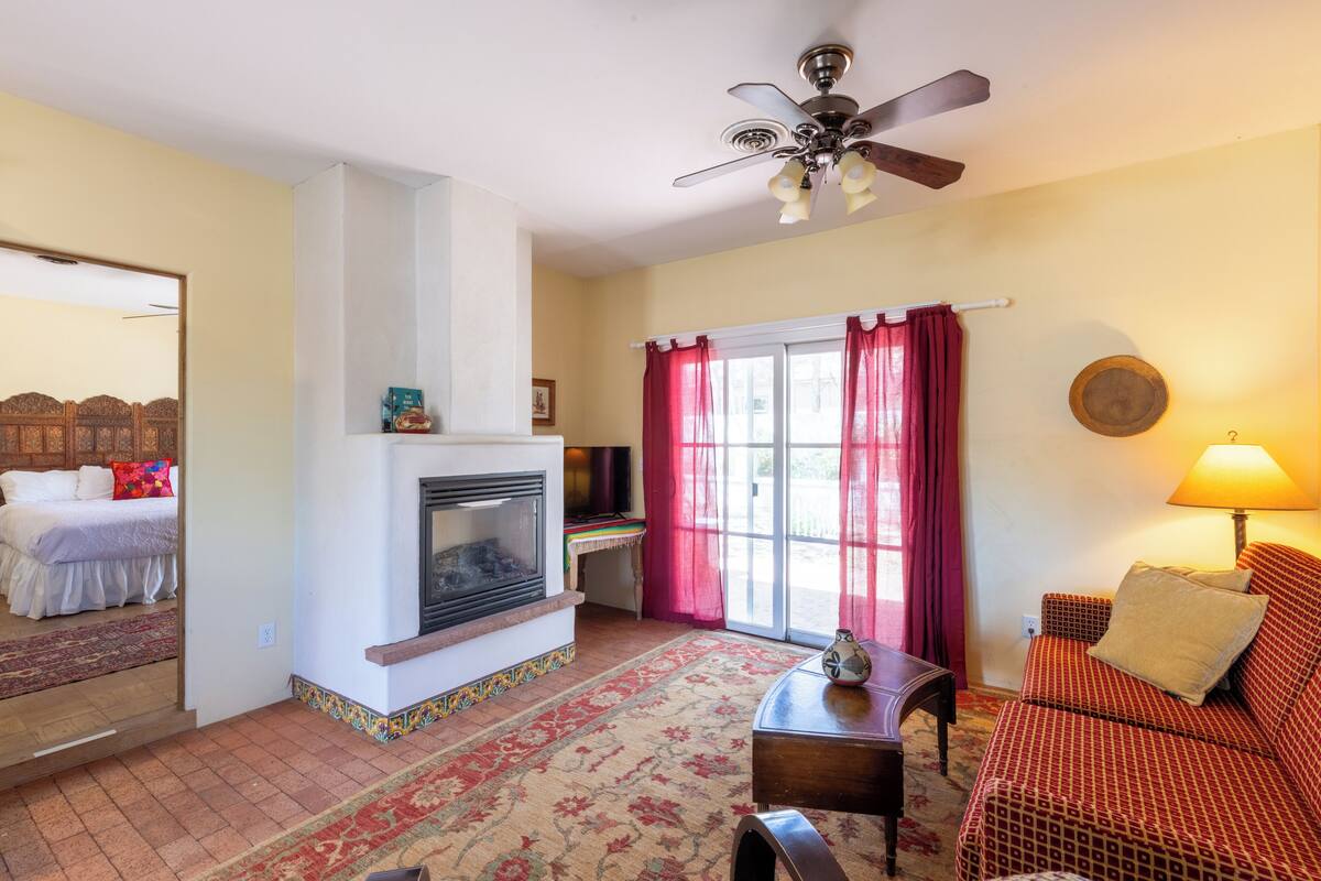 A living room with a fireplace, a sofa, a coffee table, and a television.