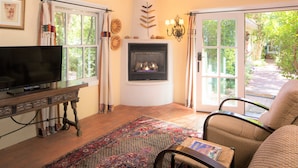 Una sala de estar acogedora con chimenea, televisión y un ventanal grande.