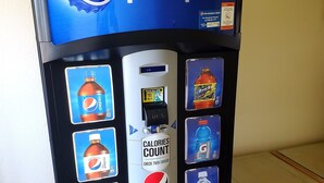 A Pepsi vending machine with a digital display, a bill insertion slot, and a coin return slot.