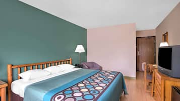 A hotel room with a bed, a desk, a television, and a chair.