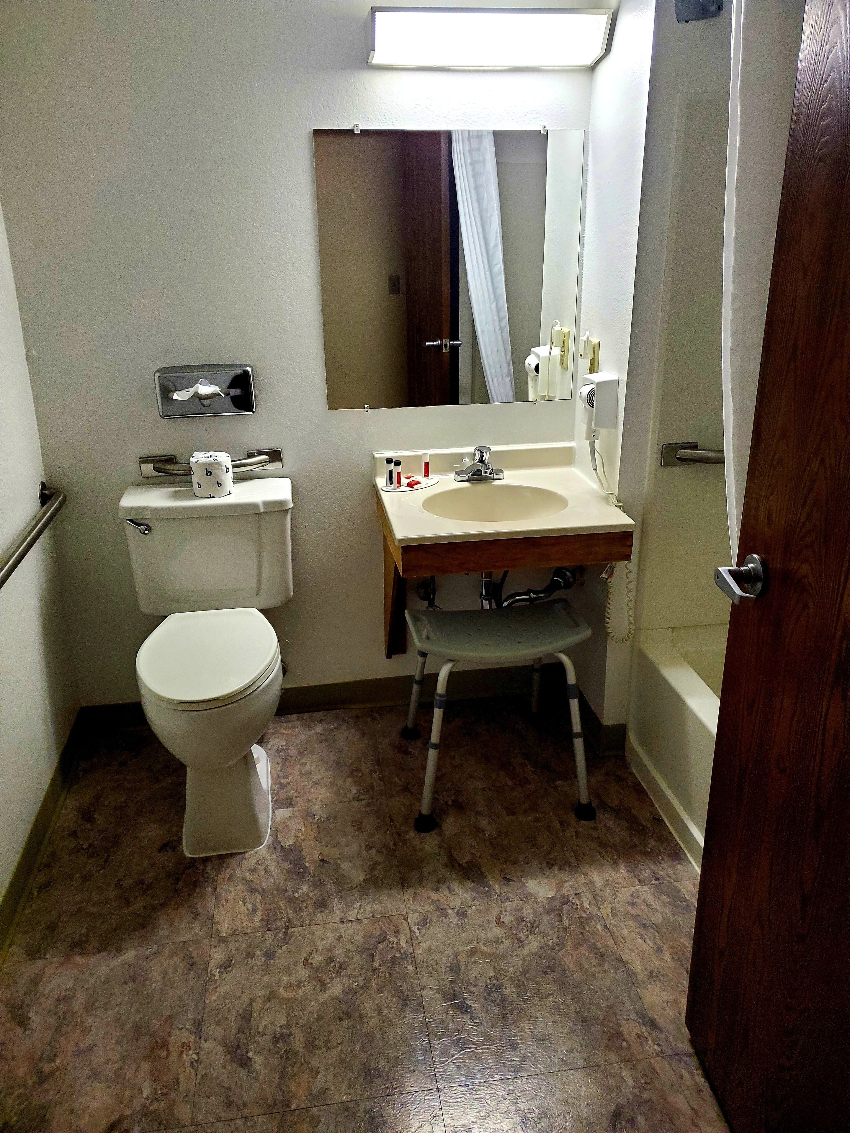 A small bathroom with a toilet, sink, and shower.