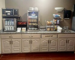 Uma cozinha compacta com micro-ondas, geladeira e diversos recipientes para armazenamento de alimentos.