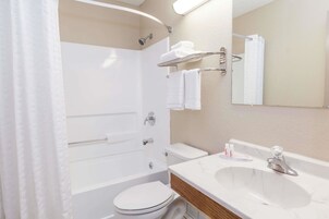 Uma casa de banho moderna com banheira, sanita e lavatório.