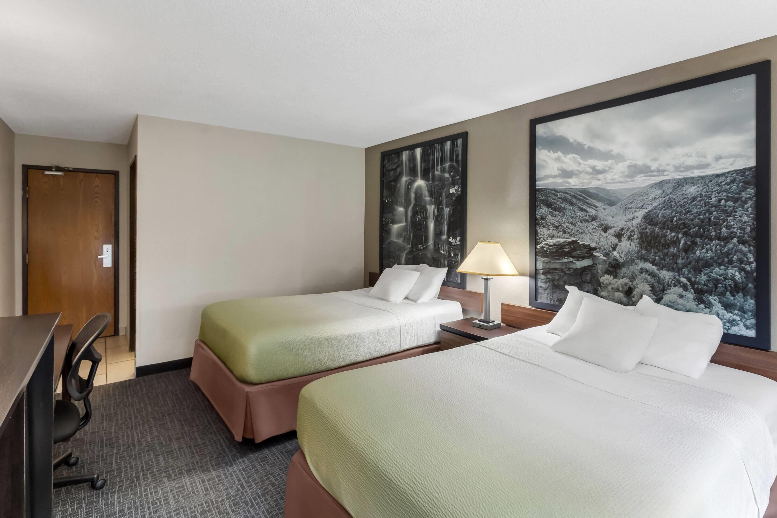 Une chambre d’hôtel avec deux lits, un bureau et une chaise.