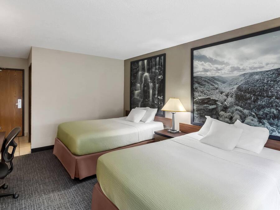 Ett hotellrum med två sängar, ett skrivbord och en stol.