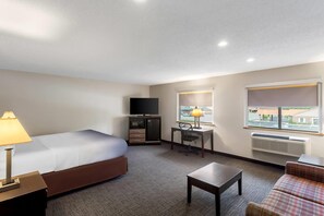 A hotel room with a bed, desk, chair, and a television. - Super 8 by Wyndham Elkins (Elkins)