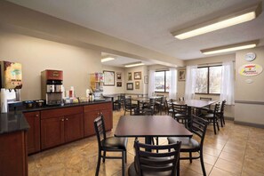 Enjoy a self-service breakfast at this hotel's dining area, featuring a central island with a coffee machine and food options.