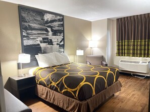 Relax in a stylish room with a large bed, nightstand, and wall-mounted air conditioning unit.