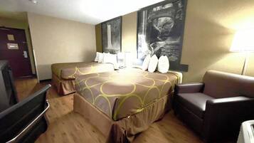 A hotel room with two beds, a sofa, a desk, and a large painting on the wall.