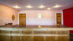 A reception area with a marble counter, wooden paneling, and a sign indicating a spa. - Econo Lodge Hornell (Hornell)
