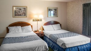 A hotel room with two beds, a nightstand with a lamp, and two framed pictures on the wall. - Econo Lodge Hornell (Hornell)